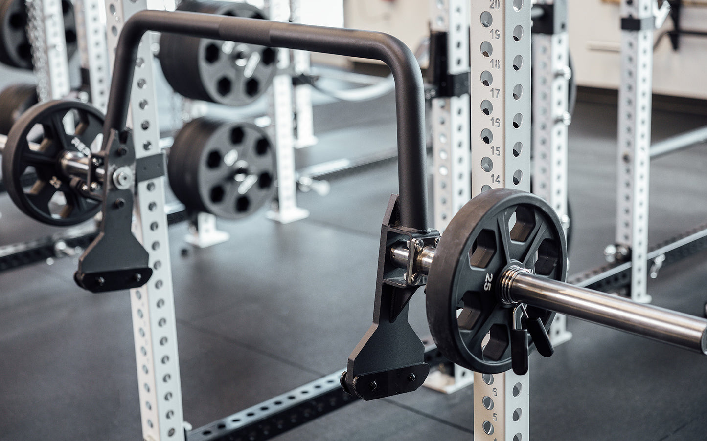 Close up of a racked REP Open Trap Bar sleeve with a 25lb plate loaded.