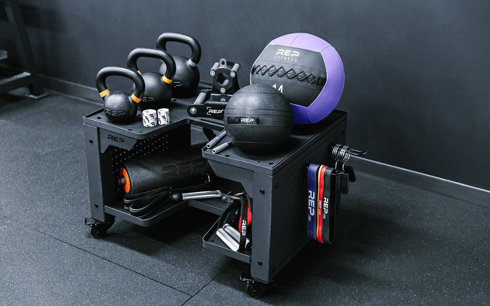 Premium heavy duty matte black storage cart with wheels in sleek matte black metal finish for organized gym equipment storage loaded with exercise balls, kettlebells and other lifting and exercise equipment from Rep Fitness UK | Shop Premium Gym Equipment for Home & Commercial Use Online