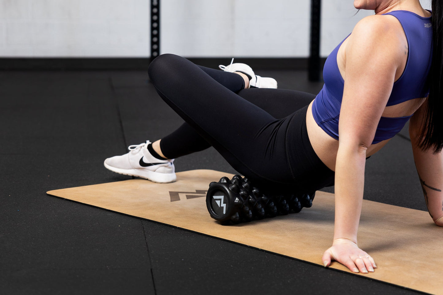 Athlete Using a High Density Foam Roller For Glutes from Rep Fitness UK | Shop Best Premium Gym Equipment for Home & Commercial Use Online
