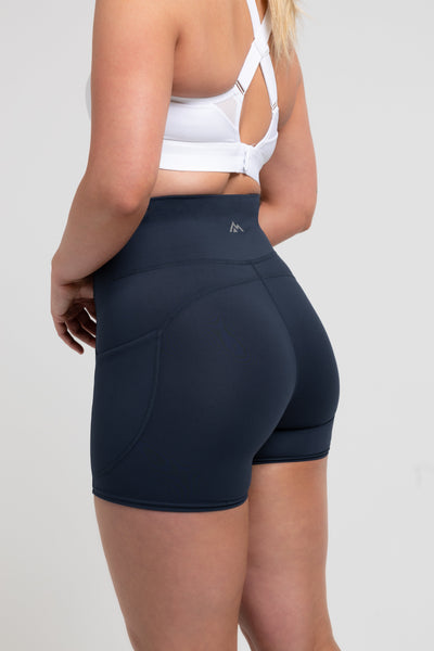 Athlete wearing the navy REP Women’s Forma Shorts.