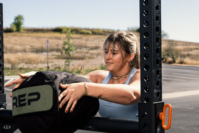 Woman doing a stone sandbag toss over a yoke