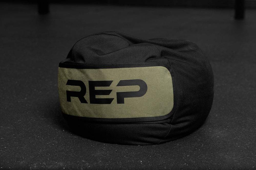 Black and green stone sandbag with 'REP' branding on a dark surface