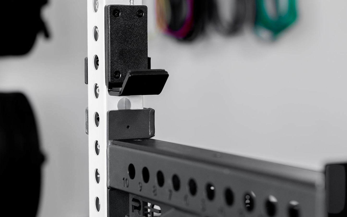 Side view of standard J-Cups 2.0 – heavy-duty barbell holder for PR-5000 power rack; 3x3” 11-gauge steel with metallic black powder coat, soft plastic lining, recessed hardware, and 1,000 lb capacity for safe, scratch-free, and stable lifting mounted on white power rack upright  from Rep Fitness UK | Shop Premium Gym Equipment for Home & Commercial Use, Best Online Gym Equipment UK