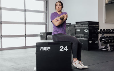 Female athlete stretching on a 24" REP Stackable Soft Plyo Box from Rep Fitness UK | Shop Best Premium Gym Equipment for Home & Commercial Use Online