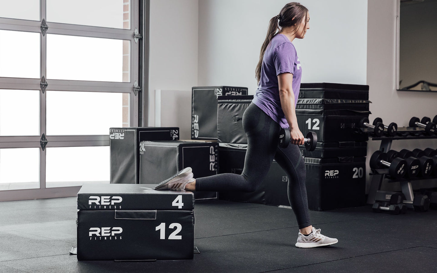 Female athlete performing a split squat with her back foot elevated on a 12" and 4" REP Stackable Soft Plyo Box from Rep Fitness UK | Shop Best Premium Gym Equipment for Home & Commercial Use Online