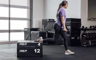 Female athlete performing a split squat with her back foot elevated on a 12" and 4" REP Stackable Soft Plyo Box from Rep Fitness UK | Shop Best Premium Gym Equipment for Home & Commercial Use Online