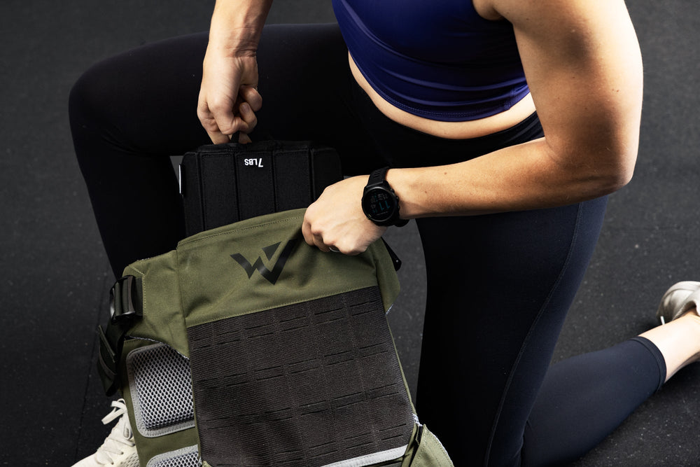 Person taking out a soft weight vest plate from the weight vest.