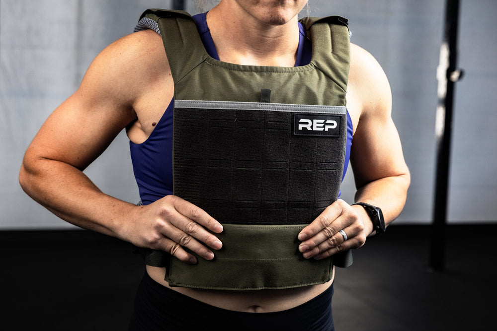 Person wearing a green weight vest with 'REP' branding against a neutral background