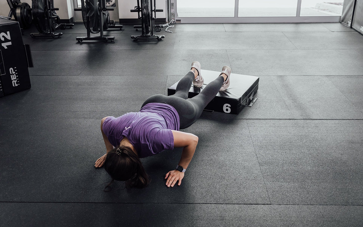 Female athlete performing deficit push-ups with her feet elevated on a 6" REP Stackable Soft Plyo Box from Rep Fitness UK | Shop Best Premium Gym Equipment for Home & Commercial Use Online