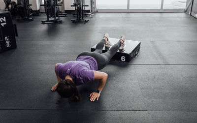 Female athlete performing deficit push-ups with her feet elevated on a 6" REP Stackable Soft Plyo Box from Rep Fitness UK | Shop Best Premium Gym Equipment for Home & Commercial Use Online