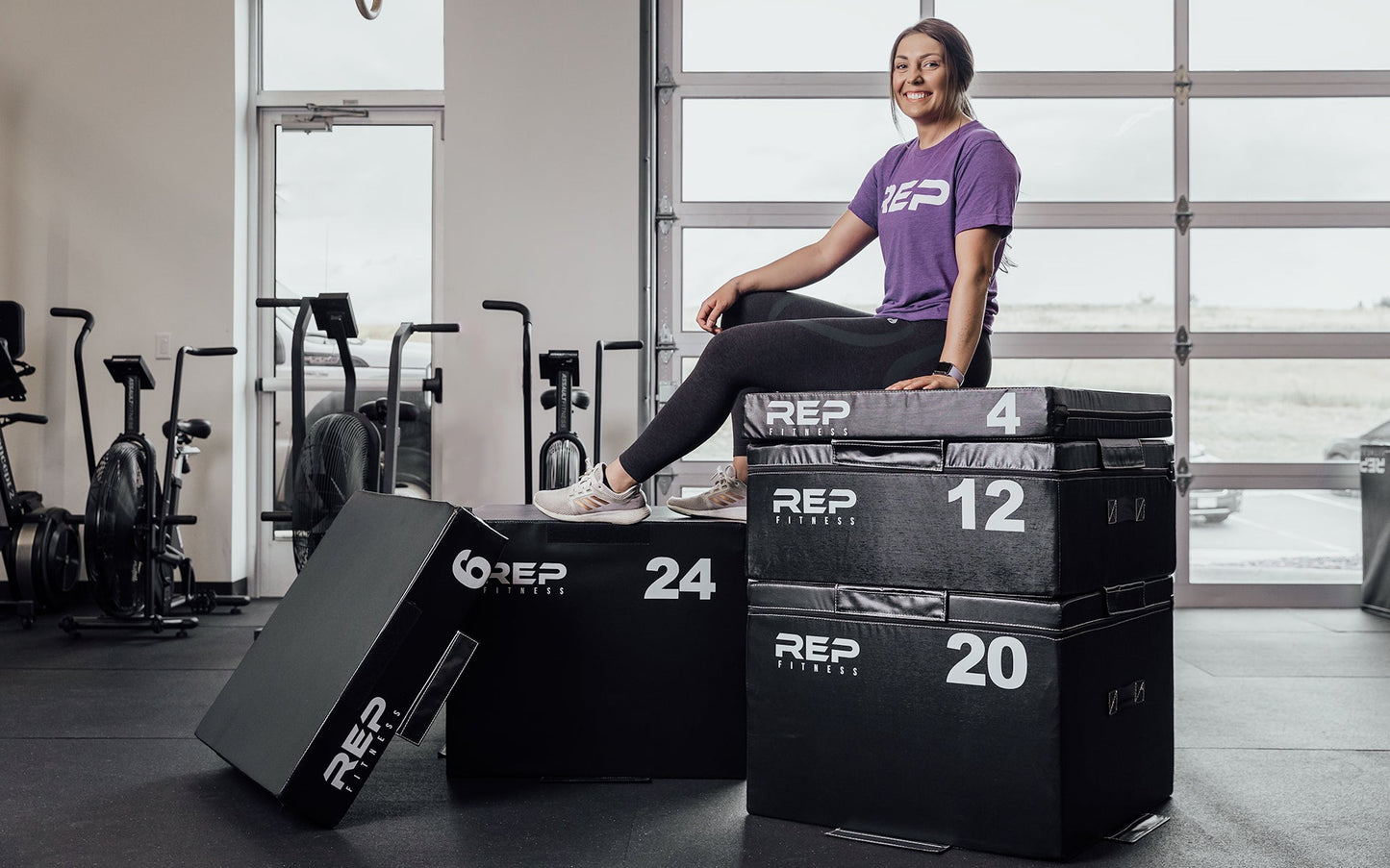 Female athlete sitting on top of a full set of REP Stackable Soft Plyo Boxes from Rep Fitness UK | Shop Best Premium Gym Equipment for Home & Commercial Use Online