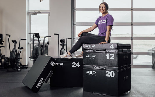 Female athlete sitting on top of a full set of REP Stackable Soft Plyo Boxes from Rep Fitness UK | Shop Best Premium Gym Equipment for Home & Commercial Use Online