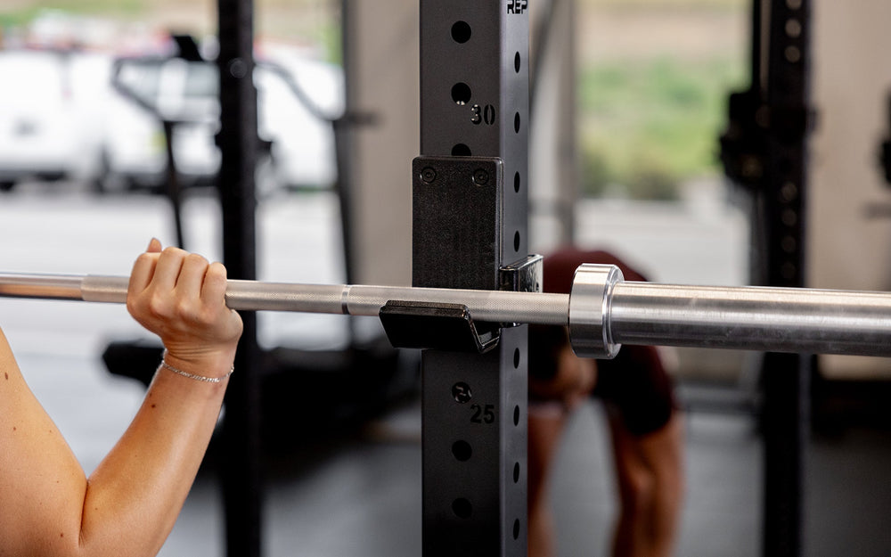Standard J-Cups 2.0 – heavy-duty barbell holder for PR-5000 power rack; 3x3” 11-gauge steel with metallic black powder coat, soft plastic lining, recessed hardware, and 1,000 lb capacity for safe, scratch-free, and stable lifting mounted on power rack upright  from Rep Fitness UK | Shop Premium Gym Equipment for Home & Commercial Use, Best Online Gym Equipment