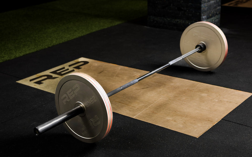 Athlete loading Rep Fitness Calibrated Steel Plates (KG) onto a barbell using the REP® x Kleva Built® Genesis Jack® 2.0 from Rep Fitness UK | Shop Best Premium Gym Equipment for Home & Commercial Use Online