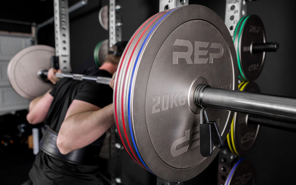 Athlete squatting with Rep Fitness Calibrated Steel Plates (KG), highlighting their thin size and IPF Specs for powerlifting from Rep Fitness UK | Shop Best Premium Gym Equipment for Home & Commercial Use Online