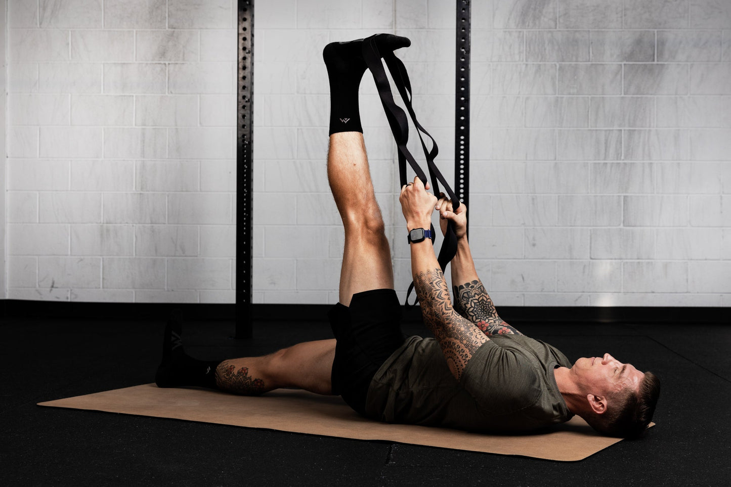Person using a looped stretching strap for assisted flexibility and mobility training from Rep Fitness UK | Shop Best Premium Gym Equipment for Home & Commercial Use Online