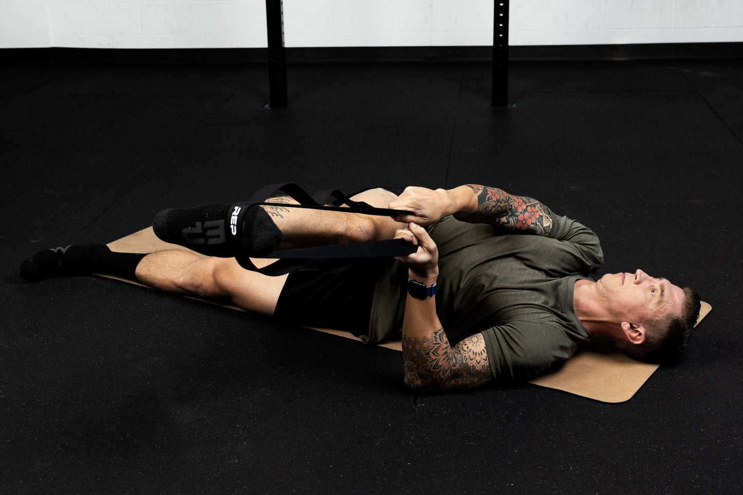 Person using a looped stretching strap for assisted flexibility and mobility training from Rep Fitness UK | Shop Best Premium Gym Equipment for Home & Commercial Use Online
