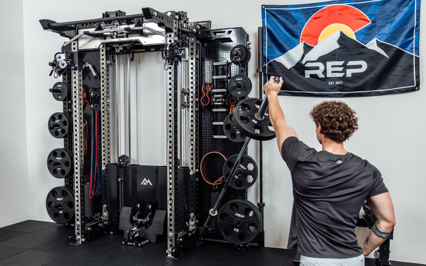 An athlete using the Rack Mounted REP® x Kleva Built® Adroit Landmine to do presses on the Wall-Mounted Ares™ 2.0 from Rep Fitness UK | Shop Premium Gym Equipment for Home & Commercial Use Online | Best Online Gym Equipment UK