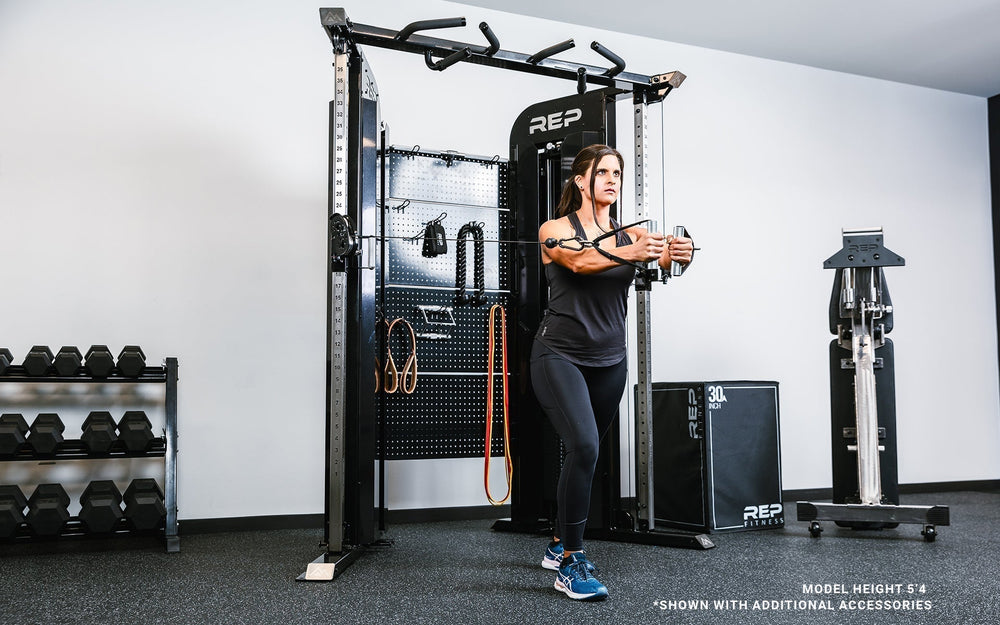 Woman doing set of arm strength exercises on Arcadia™ max stand-alone functional trainer, premium full-sized cable machine with grips hanging on the back board from Rep Fitness UK | Shop Premium Gym Equipment for Home & Commercial Use Online.