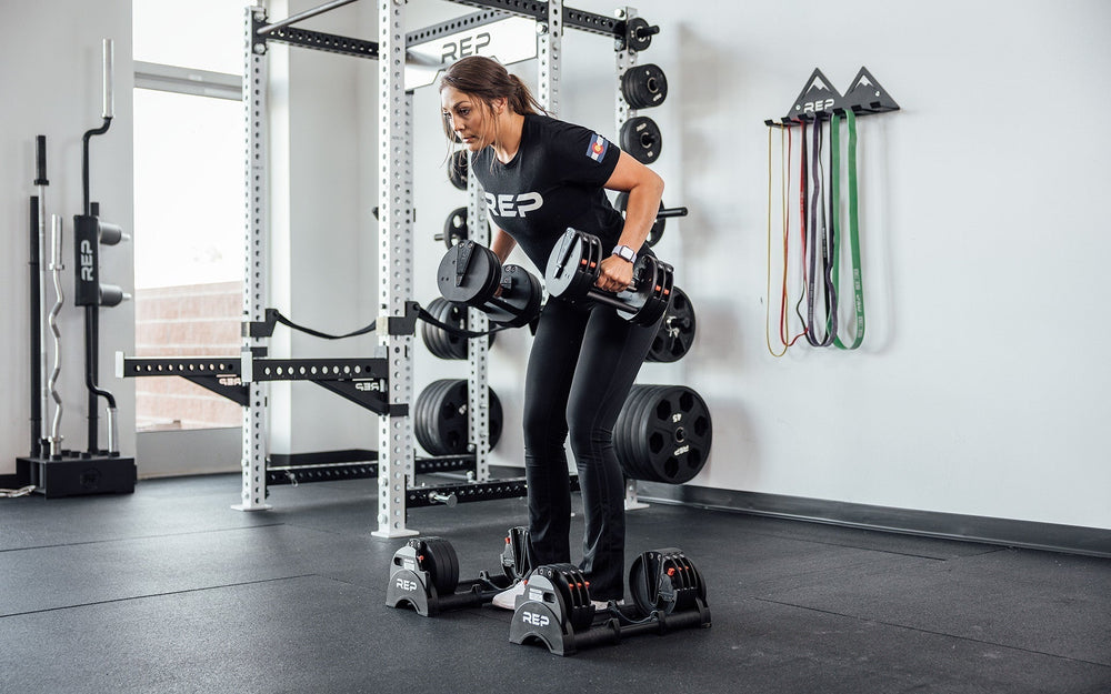 Woman doing set of upper arm reps with Premium QuickDraw dumbbells with adjustable weight, fast switch adjustable  weight range technology and secure Lock-N-Load switches for high-performance strength training from Rep Fitness UK | Shop Premium Gym Equipment for Home & Commercial Use, Best Online Gym Equipment UK