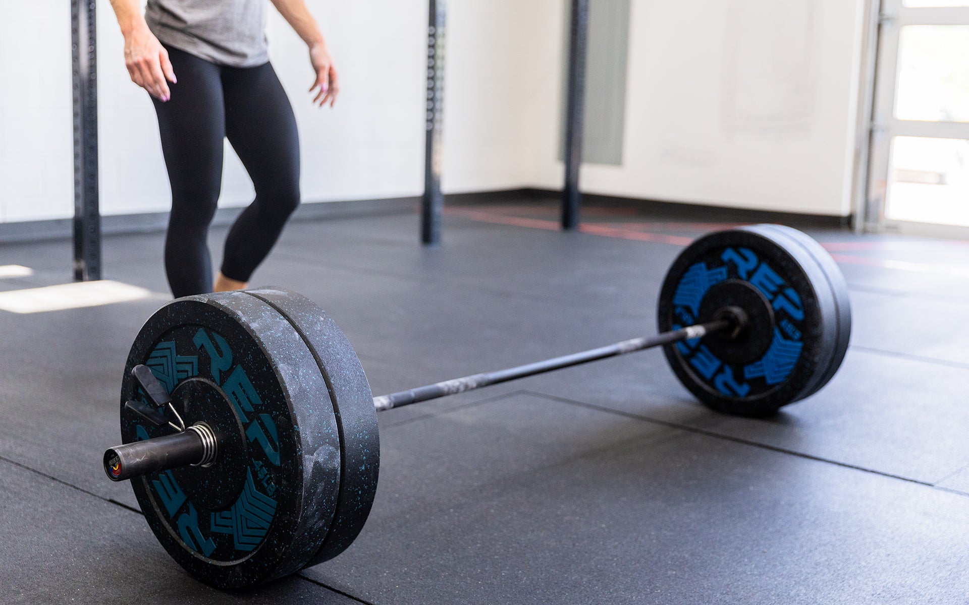 Woman using 15 kg Colorado Bar weightlifting bar, ideal for strength training and gym workouts from Rep Fitness UK | Shop Premium Gym Equipment for Home & Commercial Use Online| Best Online Gym Equipment UK