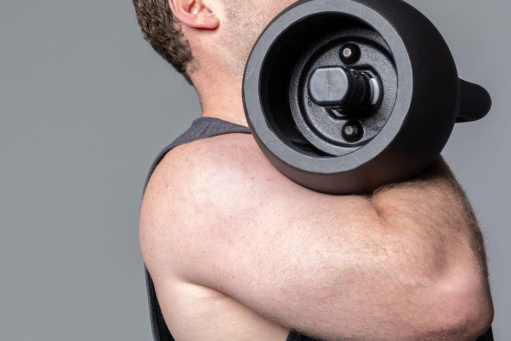 man Exercising uppers arm with the adjustable kettlebell from Rep Fitness UK, quick weight adjustment, non-slip matte powder coat, rubber base, and versatile for home gyms| Shop Premium Gym Equipment for Home & Commercial Use, Best Online Gym Equipment UK