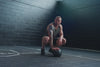 Athlete using a slam ball in the black Men’s Motus Shorts