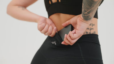 A video of an athlete putting their phone into the hidden pocket on the Women's Eos Tights