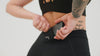 A video of an athlete putting their phone into the hidden pocket on the Women's Eos Tights