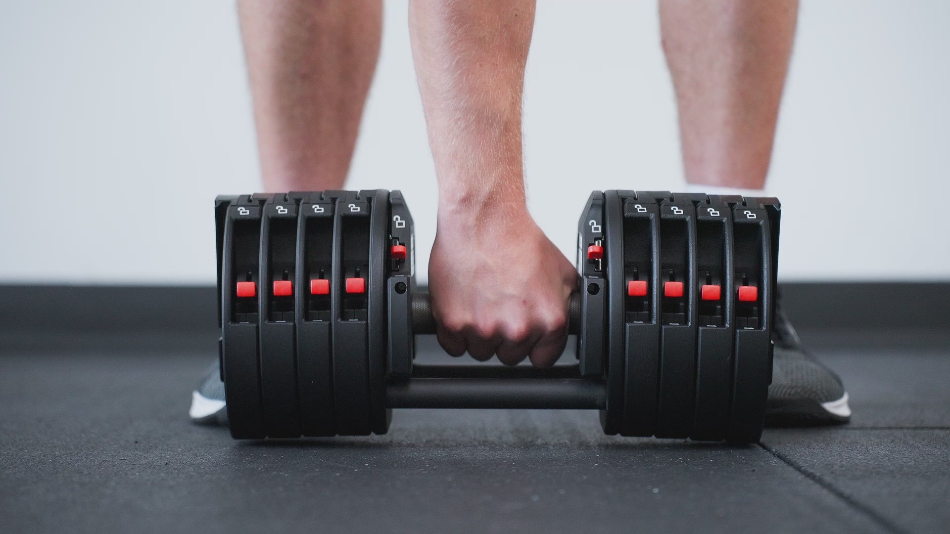 Man gripping handle of durable Premium QuickDraw dumbbells with adjustable weight, fast switch adjustable  weight range technology and secure Lock-N-Load switches for high-performance strength training from Rep Fitness UK | Shop Premium Gym Equipment for Home & Commercial Use, Best Online Gym Equipment