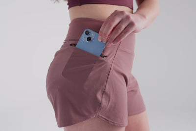 Video: Athlete putting their phone in the zipper pocket of the Mauve REP Artemis Short
