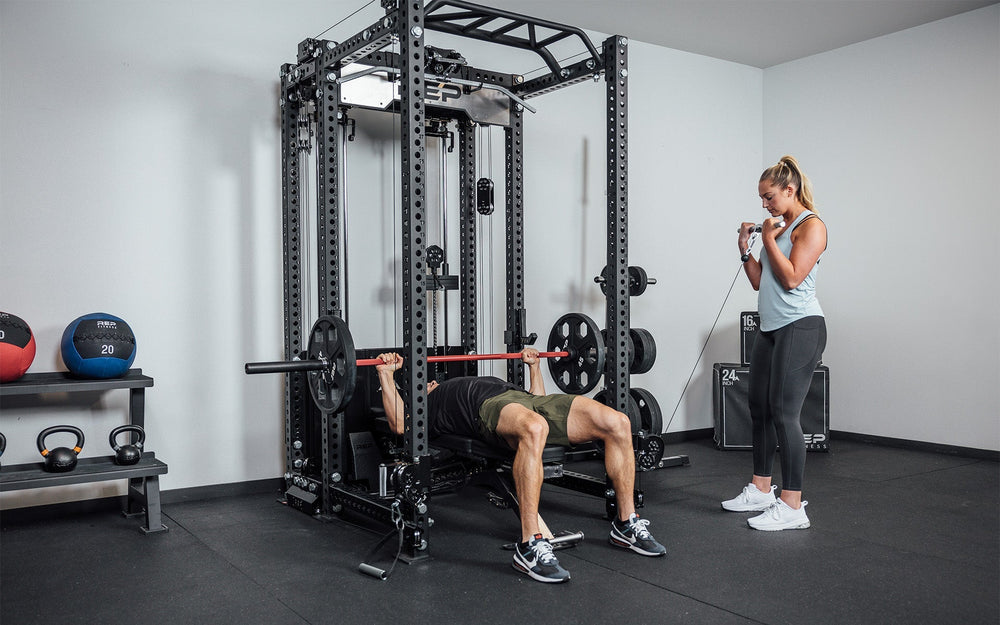 woman using pulley and man using bar on Ares™ 2.0 cable attachment – fully integrated functional trainer and lat pulldown/low row for PR-5000 power racks, featuring dual weight stacks, smooth swivel pulleys, and versatile unilateral or bilateral training options from Rep Fitness UK | Shop Premium Gym Equipment for Home & Commercial Use, Best Online Gym Equipment UK